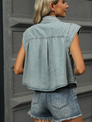 Sleeveless light wash denim utility shirt jacket with button front and pleat detail.