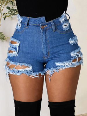 Distressed denim shorts in medium wash with bold cutouts and frayed hem.
