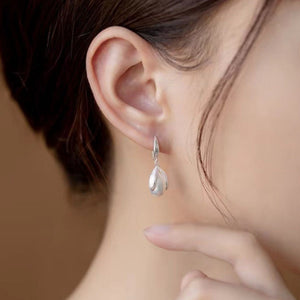 Lustrous pearl drop earrings with silver setting, delicate and elegant.