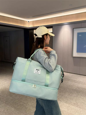 Light green duffel bag with two zippered compartments and light green straps.