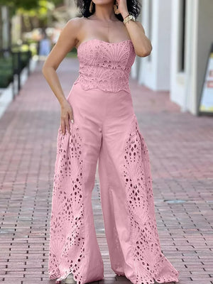 Pink strapless openwork top and wide-leg pants set with intricate cut-out details.