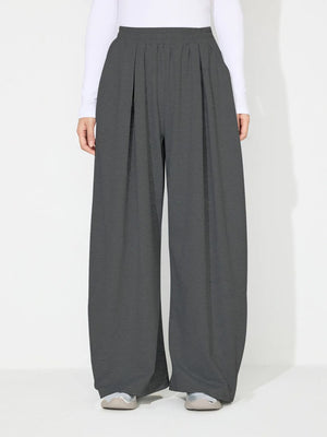 Dark gray pleated drape palazzo trousers with a wide leg and elastic waistband.