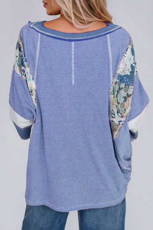 Patchwork stripe raglan tee in dusty blue with artistic sleeve details and a relaxed fit.