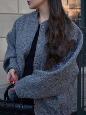 Dark gray boucle cocoon jacket with snap closure and round neckline.