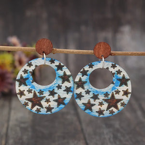 Multicolor celestial starburst wood hoop earrings with a blue sky pattern.