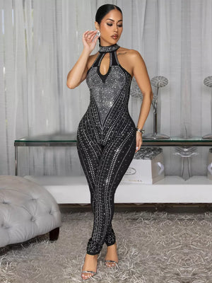 Black halter neck romper with rhinestone embellishments and cutout detail.