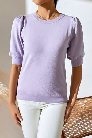 Lilac knit sweater with puff sleeves and crewneck, styled with white jeans.