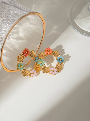 Gold halo hoop earrings with beaded floral details in pastel colors