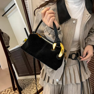 Black suede crossbody bag with gold hardware and zipper detail