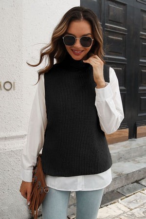 Black ribbed knit turtleneck vest with side buttons, acrylic, worn over a white shirt.