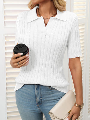 White cable knit polo sweater with short sleeves and a collar.