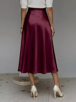 Wine red satin A-line midi skirt with pockets, flowing silhouette.