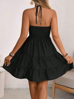 Black ruched halter tiered mini dress with ruffles and a tie back.