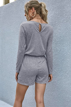 Gray jersey romper with long sleeves, elastic waist, and keyhole back detail.