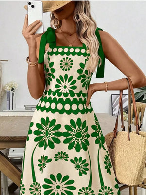 Charming floral tie-shoulder midi dress in cream with green floral print and scalloped trim.