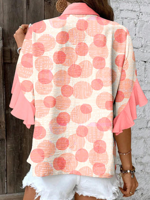 Polka dot blouse with ruffle sleeves and a collared neckline.