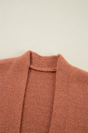 Open-front cropped knit cardigan in burnt coral acrylic with a textured neckline detail.