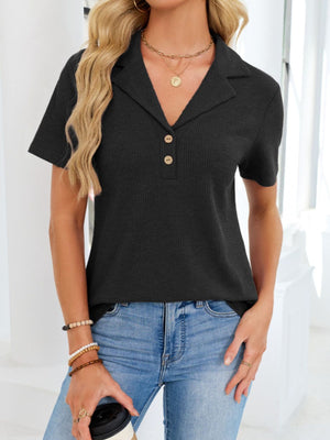 Black waffle knit polo shirt with button placket and collared neckline.