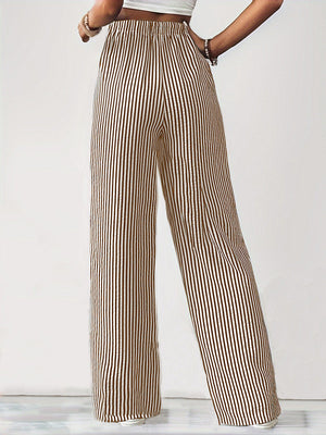 Wide-leg drawstring trousers in black and white vertical stripes with an elastic waistband.