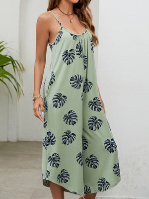 Sage green culotte jumpsuit with monstera print, gathered bust and spaghetti straps.