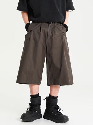 Men's chocolate wide leg shorts with pleats and belt loops.