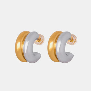 Dual-tone sculptural C-hoop earrings in gold and silver with a polished finish.