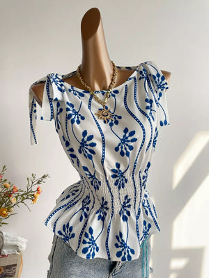 White and blue botanical print smocked shoulder blouse with tie details.