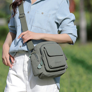 Green lightweight nylon crossbody bag with multiple pockets and adjustable strap.