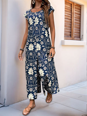 Botanical print culotte jumpsuit in dark green with short sleeves and a scoop neck.