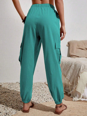 Turquoise cargo lounge trousers with elastic waist and cuffs, and side pockets.