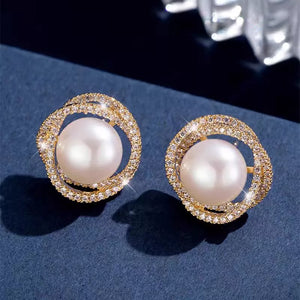 Gold pearl and zircon stud earrings with intricate pavé detailing.
