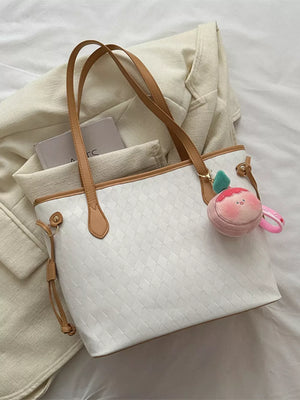 Textured diamond woven tote bag in white with tan straps and a plush charm.