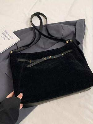 Black slouchy crossbody bag with gold accents and adjustable strap