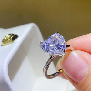 Silver ring with a large, clear heart-cut moissanite solitaire stone.
