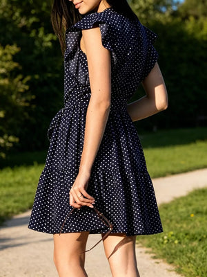 Navy polka dot dress with ruffle sleeves and tie waist, tiered skirt.