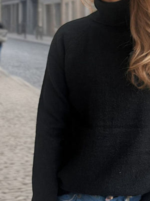 Black relaxed raglan turtleneck knit sweater with a soft texture.