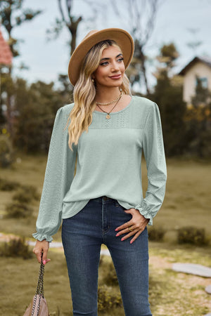 Sage perforated waffle knit blouse with ruffled cuffs and puff sleeves.