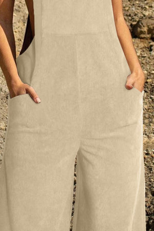 Corduroy overalls in tan with wide legs and front pockets.