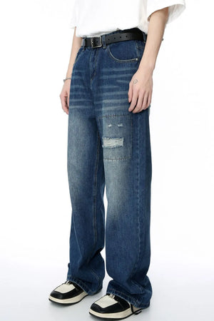 Baggy denim jeans in medium wash with patchwork and distressed details.