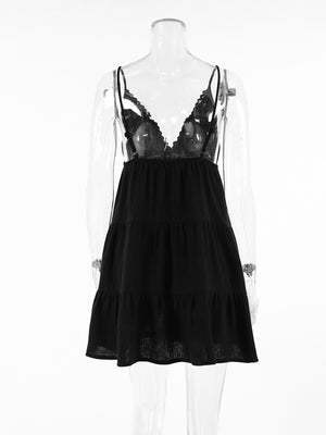 Black cotton tiered mini dress with lace trim and spaghetti straps.