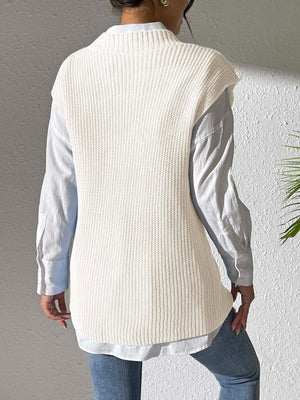 Ivory ribbed knit vest with mock neck, styled over a light blue button-down shirt.