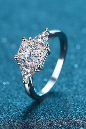 Silver trilogy ring with three clear prism-cut stones and bead-set prongs.