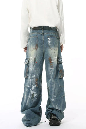 Artisan denim cargo pants in medium wash with paint splatters and wide legs.