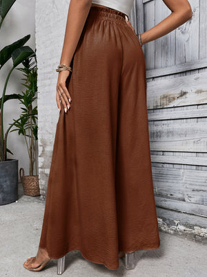 Brown ruffled waistline palazzo trousers with a wide leg and textured fabric.