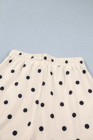 White polyester bikini bottoms with navy polka dots and elastic waistband.