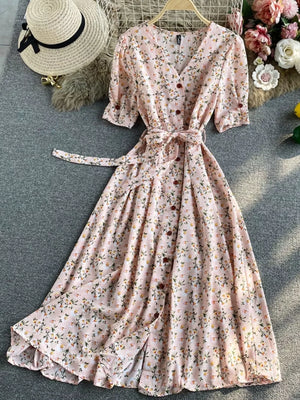 Pink floral v-neck midi dress with button front, belted waist, and short sleeves.