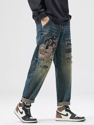 Men's distressed blue cotton jeans with patchwork teddy bear and bandana prints.