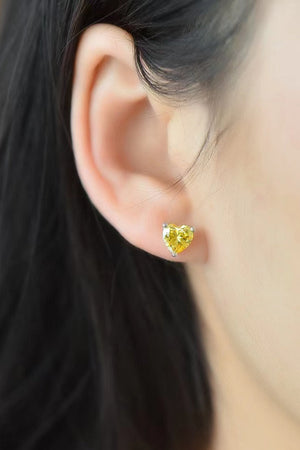 Yellow heart moissanite stud earrings on a woman's ear.