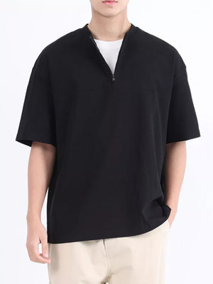Black cotton half-zip t-shirt with short sleeves and a relaxed fit.