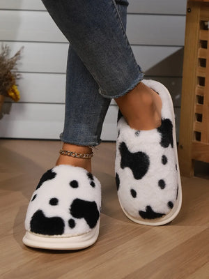 Cow print faux fur house slides in black and white, with a plush finish.